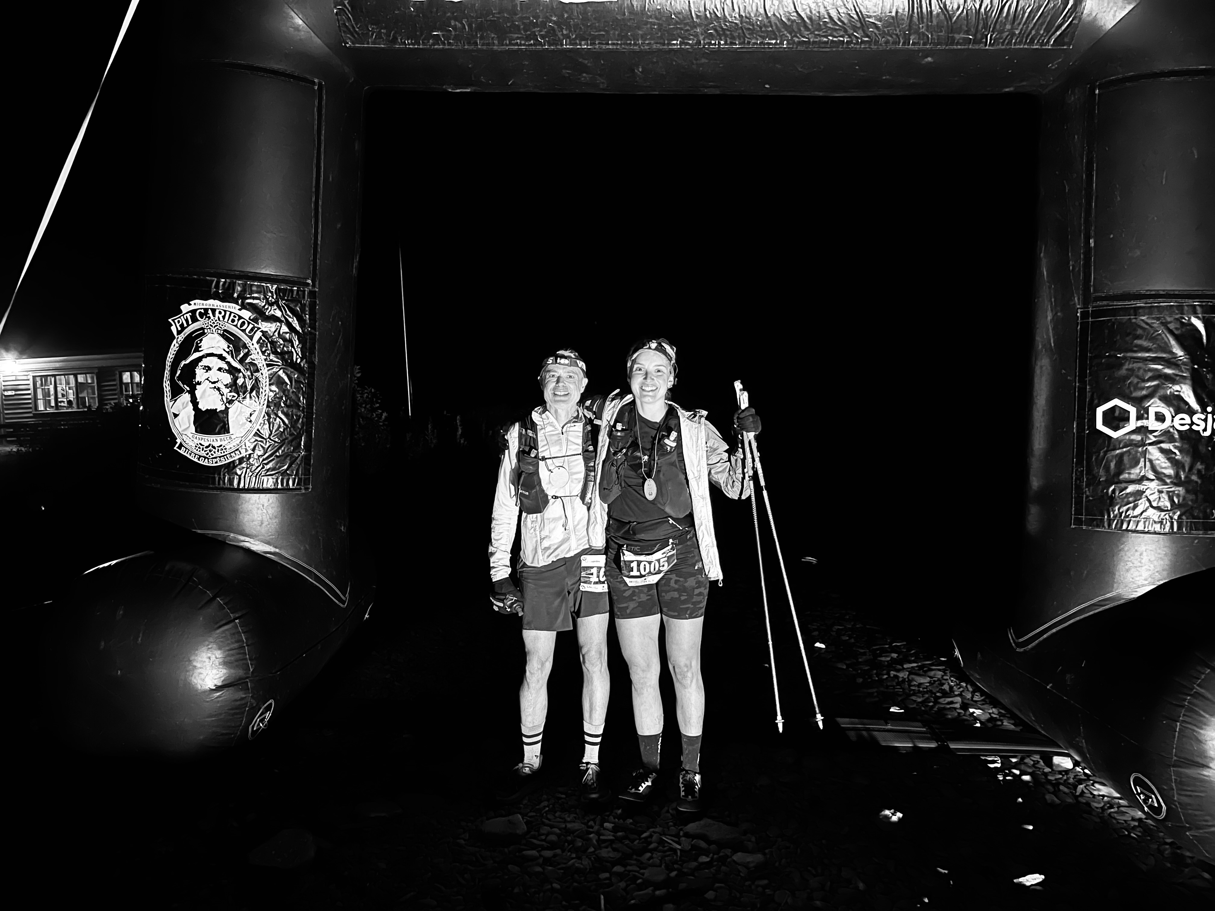 Rob Lee and his partner crossing a 100km ultra marathon finish line at night